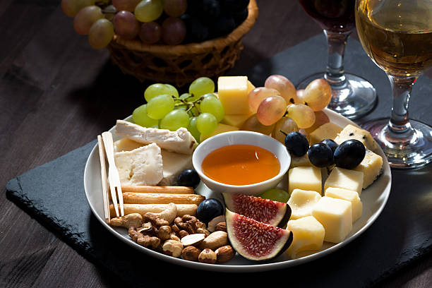 istock Plate with deli snacks and wine on dark background, closeup 497091378