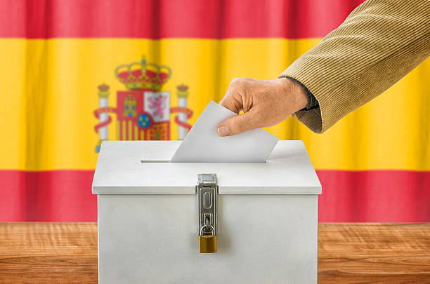 istock Man putting a ballot into a voting box - Spain 497091442