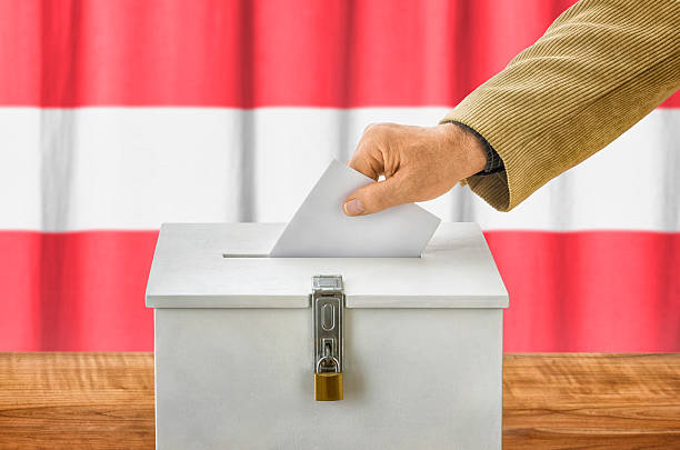 istock Man putting a ballot into a voting box - Austria 497091524