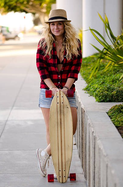 istock Smiling young woman posing with skateboard 497098737
