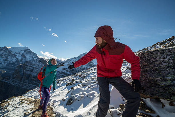 istock Hiker helping partner on mountain trail 497099776