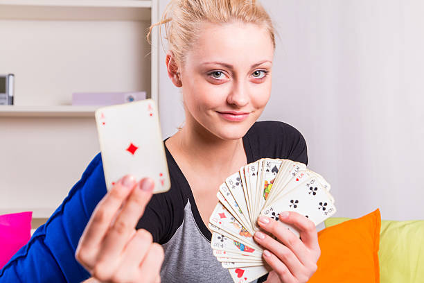 Happy woman holding a ace card while playing