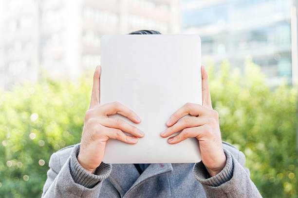istock Businessman holding up a tablet in front of his face 497100020