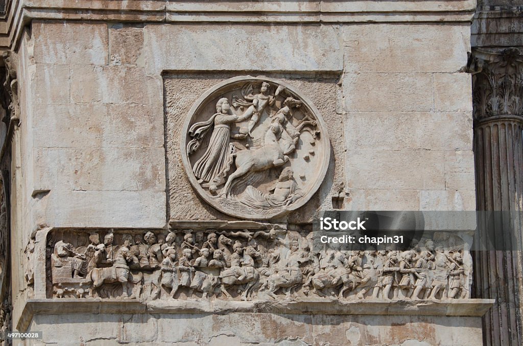 Arch of Constantine in Rome, Italy The Arch of Constantine stands just outside the Roman Colosseum and was built by the Senate in 315 A.D. to honor the victories of the Emperor Constantine, specifically the Battle of Milvian Bridge.  It is also the only known arch to have successfully reused sculptures taken from other monuments. 2015 Stock Photo