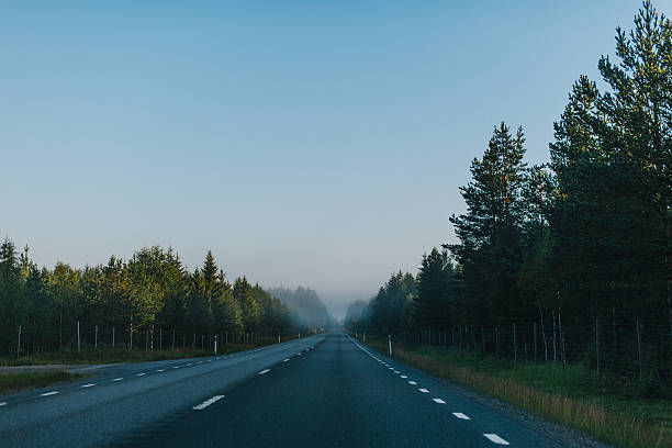 Single lane highway without any traffic at sunset