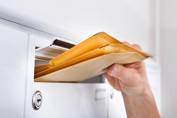 postman putting buchstaben im briefkasten - opening mail letter envelope stock-fotos und bilder