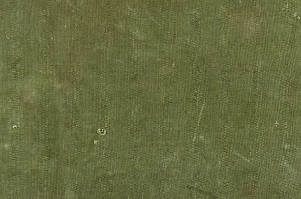 Photo of Olive green cotton texture with scratches ans rips