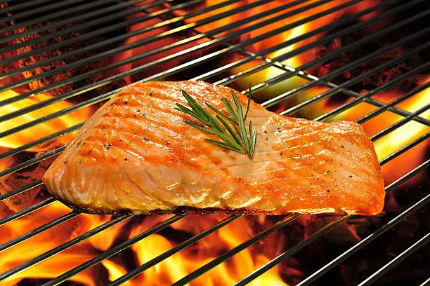 Grilled salmon on the flaming grill.