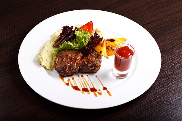 istock dish with meat, potatoes and herbs on a white plate 497104680