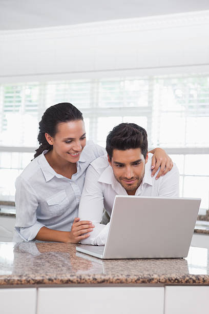 istock Happy couple using laptop together at the counter 497110091