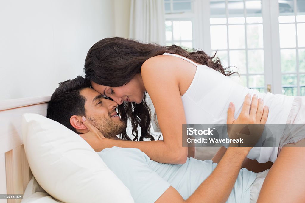 Lindo par abrazar en la cama - Foto de stock de 20 a 29 años libre de derechos