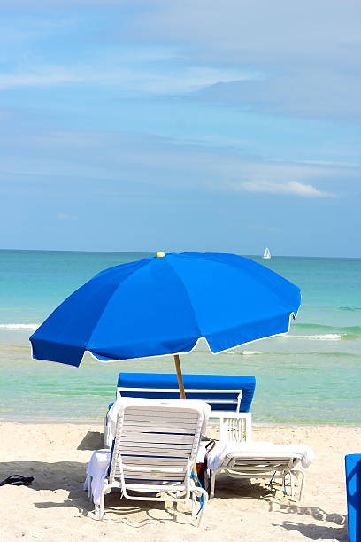 istock Beach chairs under blue umbrella on the ocean beach. 497113391