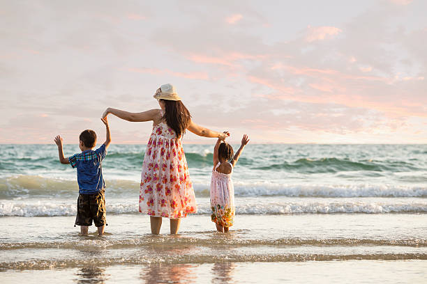 istock Happy family standing on the beach 497113985