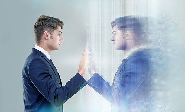 Reaching out to myself... Cropped conceptual shot of a handsome young man reaching out to his own reflectionhttp://195.154.178.81/DATA/i_collage/pi/shoots/783268.jpg mesmerised stock pictures, royalty-free photos & images