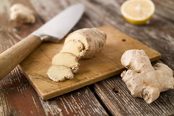 istock Sliced ginger and knife on wood cutting board rustic setting 497115962