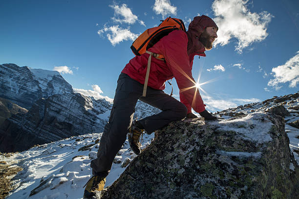 istock Young man climbs steep rock, moving up 497117424