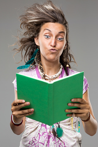 Young woman holding green book and wind is blowing her hair