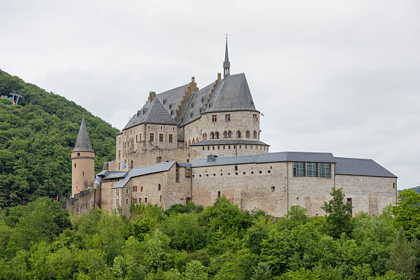 Vianden Castle, Luxembourg Europe Summer Travel Destination Vianden, Luxembourg - July 20, 2015:  Vianden Castle is located in the north of Luxembourg, near the border of Germany, nestled into and surrounded by trees.  It is a very large fortified castle in Europe, with its origins dating back to as late as the 10th century.  It is now a popular tourist attraction after falling into disrepair for a number of years.  vianden stock pictures, royalty-free photos & images