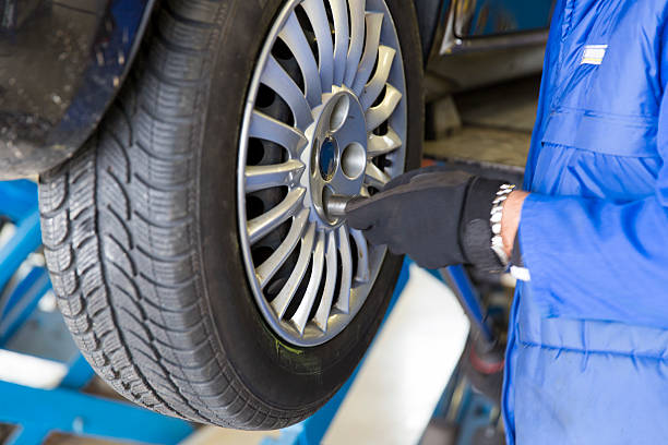 istock Auto mechanic is changin tire...prepairing car for winter 497121420