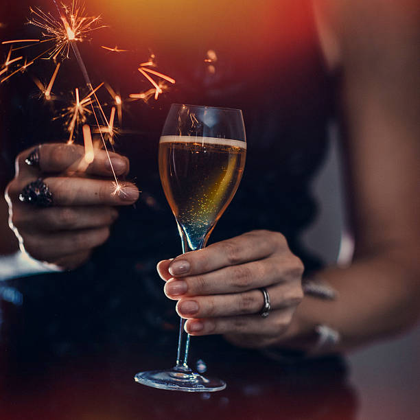 Woman holding champagne and sparkler close-up