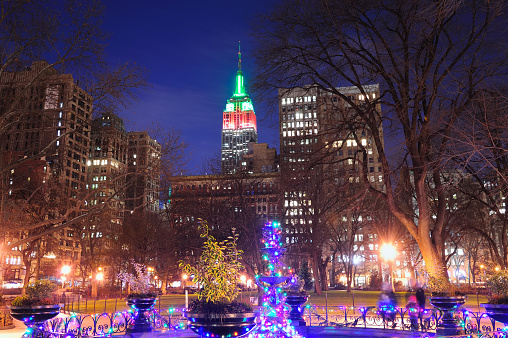 New York City Madison Square park view with Christmas color lights and Manhattan skyscrapers.