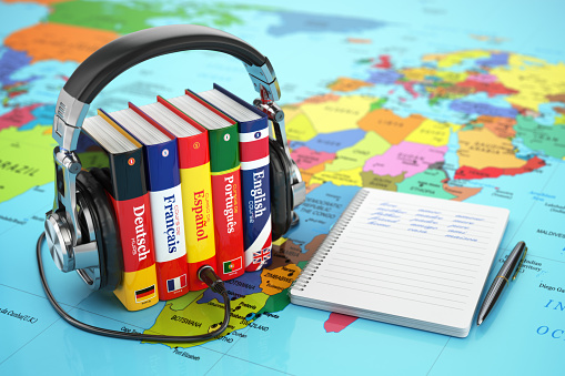 Learning languages online. Audiobooks concept. Books and headphones on the map world. 3d