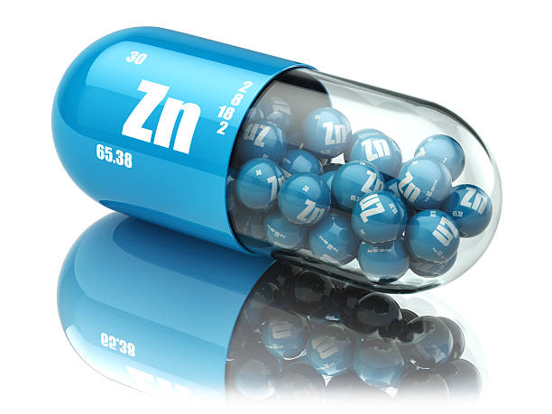 pílulas com zinco zn element complementos alimentares. vitamina de cápsulas - zinc mineral nutritional supplement pill - fotografias e filmes do acervo
