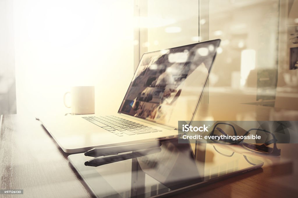 Office workplace with laptop and smart phone Office workplace with laptop and smart phone on wood table and london city blurred background 2015 Stock Photo