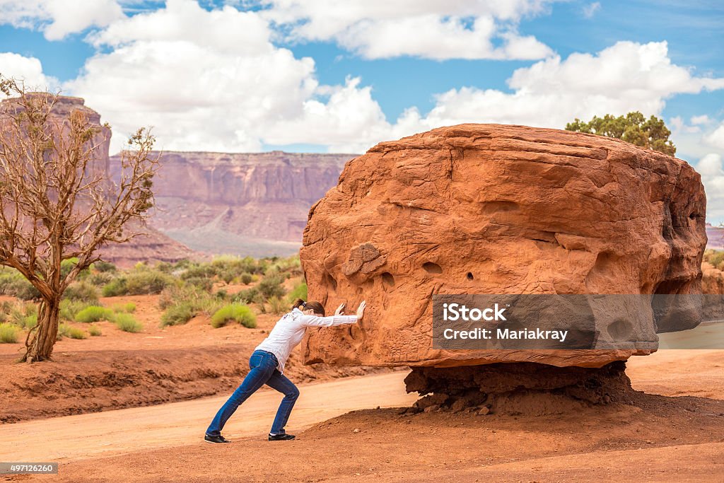 Big stone Girl pushing stone, impossible cocept Rock - Object Stock Photo