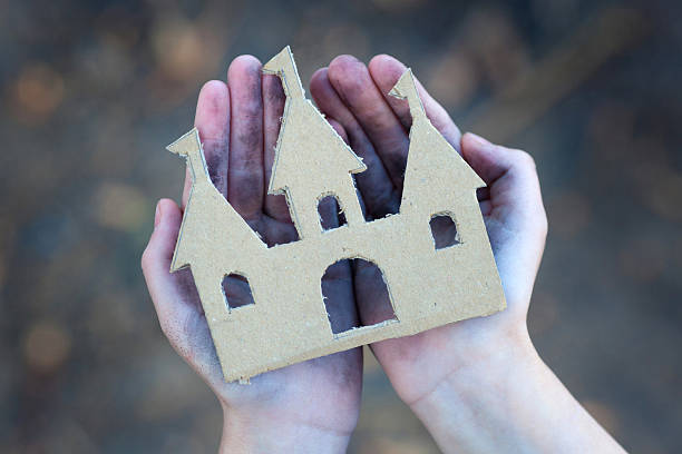 istock homeless boy holds a cardboard castle 497126700