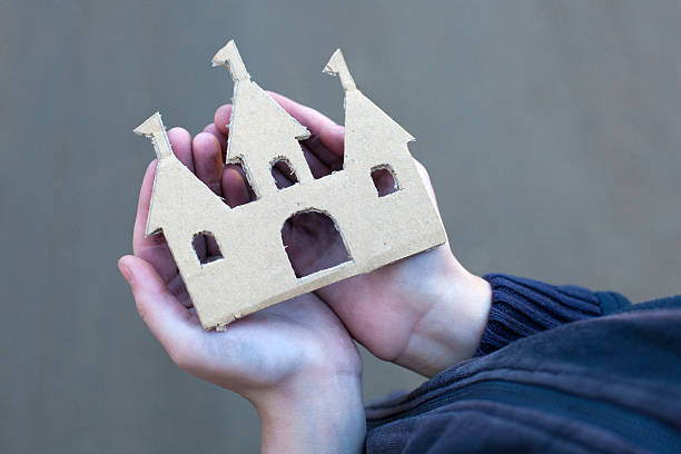 istock homeless boy holds a cardboard castle 497127046