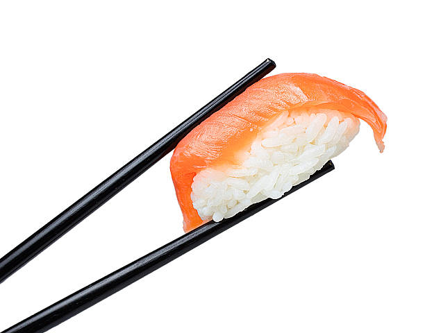 istock Salmon sushi nigiri in chopsticks isolated on white background 497127542