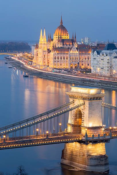 blick auf die kettenbrücke und das parlament in budapest in der dämmerung - chain bridge budapest night bridge stock-fotos und bilder