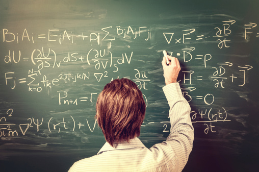 Man standing against chalkboard, solves physics equations, rear view, retro
