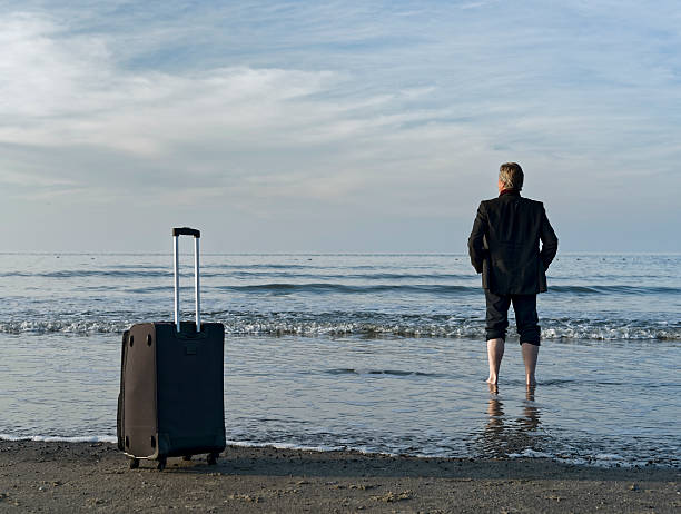 istock Businessman barefoot at beach in water 497131330