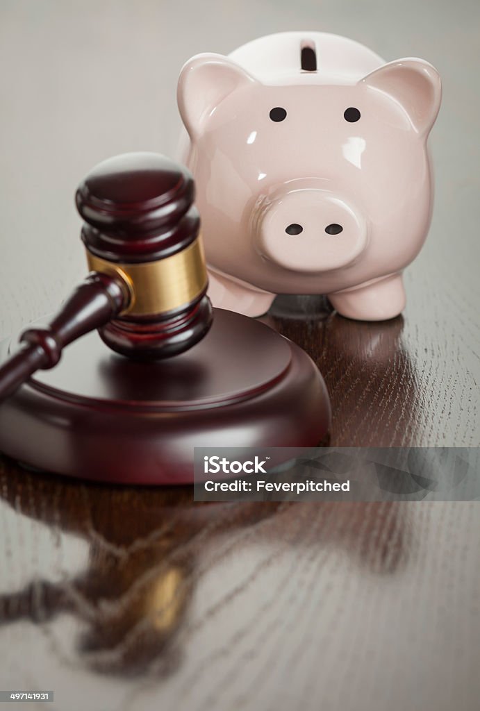 Gavel and Piggy Bank on Table Gavel and Piggy Bank on Reflective Wooden Table. Authority Stock Photo