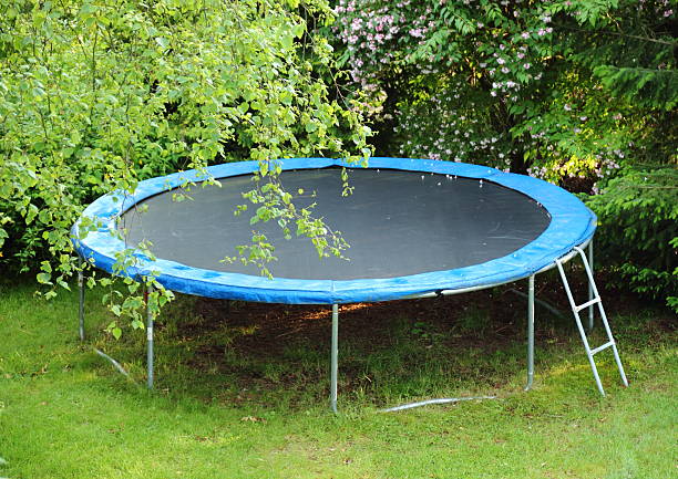 blue trampoline sur la pelouse dans le jardin - streched out photos et images de collection