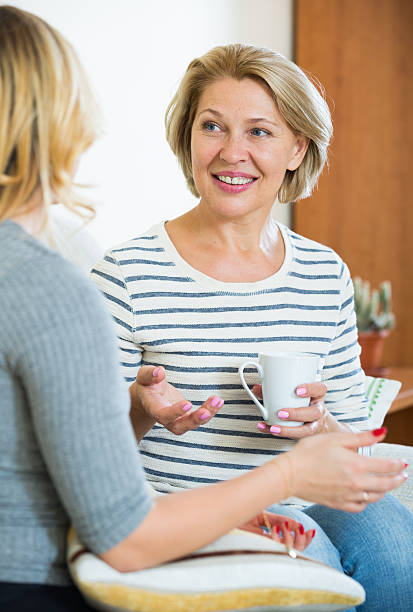 istock Two women drinking tea and talking at domestic interior 497144910