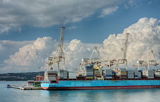 Container ship in industrial seaport of Koper in Slovenia Container ship in industrial seaport of Koper in Slovenia  in a summer cloudy day koper slovenia stock pictures, royalty-free photos & images