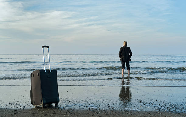 istock Businessman standing barefooted seaside in water 497145916