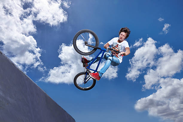 You gotta be brave to try this Full length shot of a teenage boy riding a BMX at a skateparkhttp://195.154.178.81/DATA/i_collage/pi/shoots/783328.jpg bicycle stunts stock pictures, royalty-free photos & images