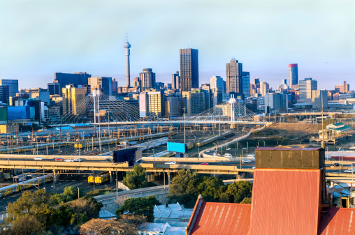 Johannesburg cityscape, taken late afternoon, showing the M1 highway. The old Newtown suburb in the foreground with the railway line leading to Park station under Nelson Mandela bridge.