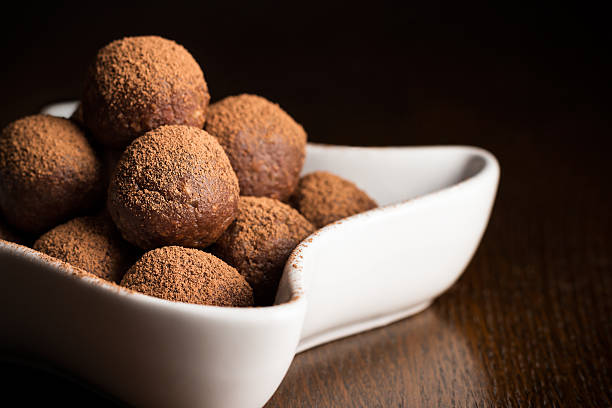 istock Chocolate truffles in bowl on dark wooden table 497147900