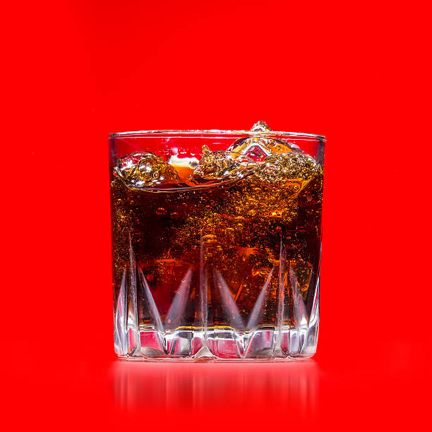 istock Glass with whiskey splash on red background 497148699