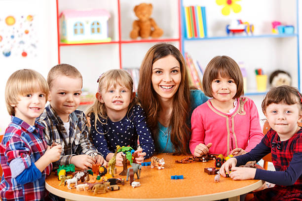 istock Young woman playing with kids in nursery school 497149209