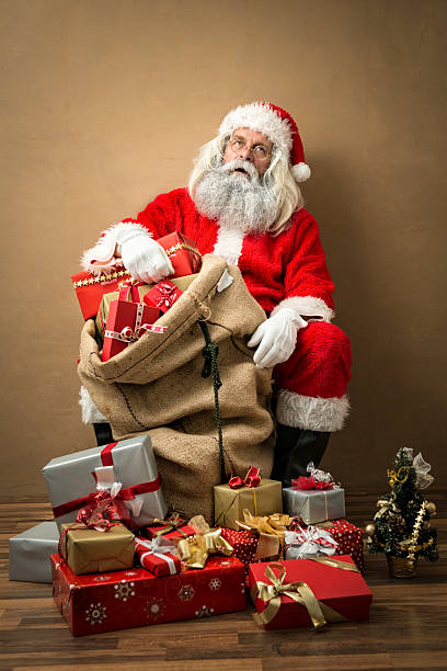 istock tired looking santa claus with many gifts 497152248