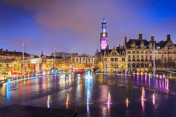 Bradford Town Hall and Centenary Square at night Dramatic night shot of Bradford Town Hall reflected in the mirror pool in the city park. Built in 2011 at a cost of over £24 million, it is hoped that the city park will attract extra tourists into the city centre. west yorkshire stock pictures, royalty-free photos & images