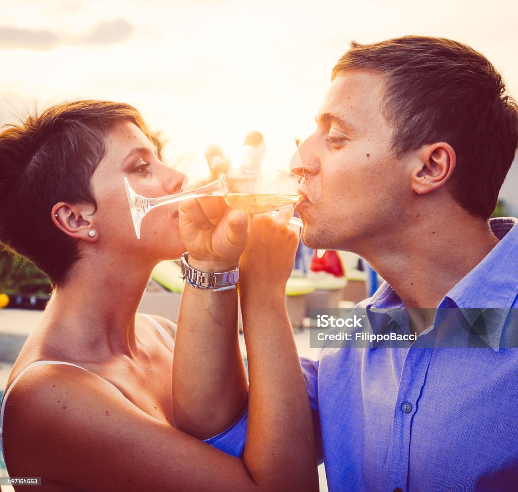 Young couple having aperitif near the swimming pool Couple - Relationship Stock Photo