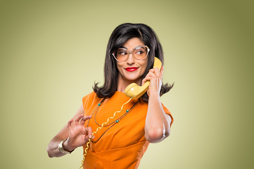 Quirky stylish woman with yellow vintage rotary telephone.