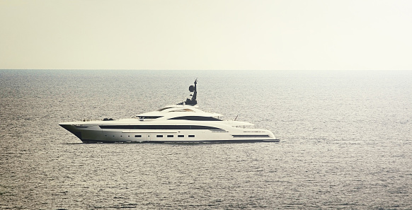 Large modern Super Yacht at sea off Monaco.  Filtered image with warm sunlight colour
